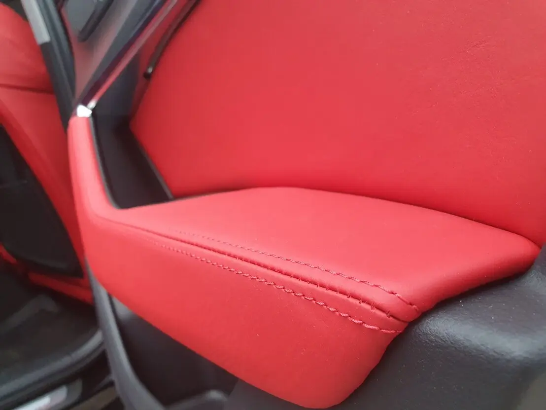 Zbliżenie na naprawiony fragment tapicerki fotela samochodowego